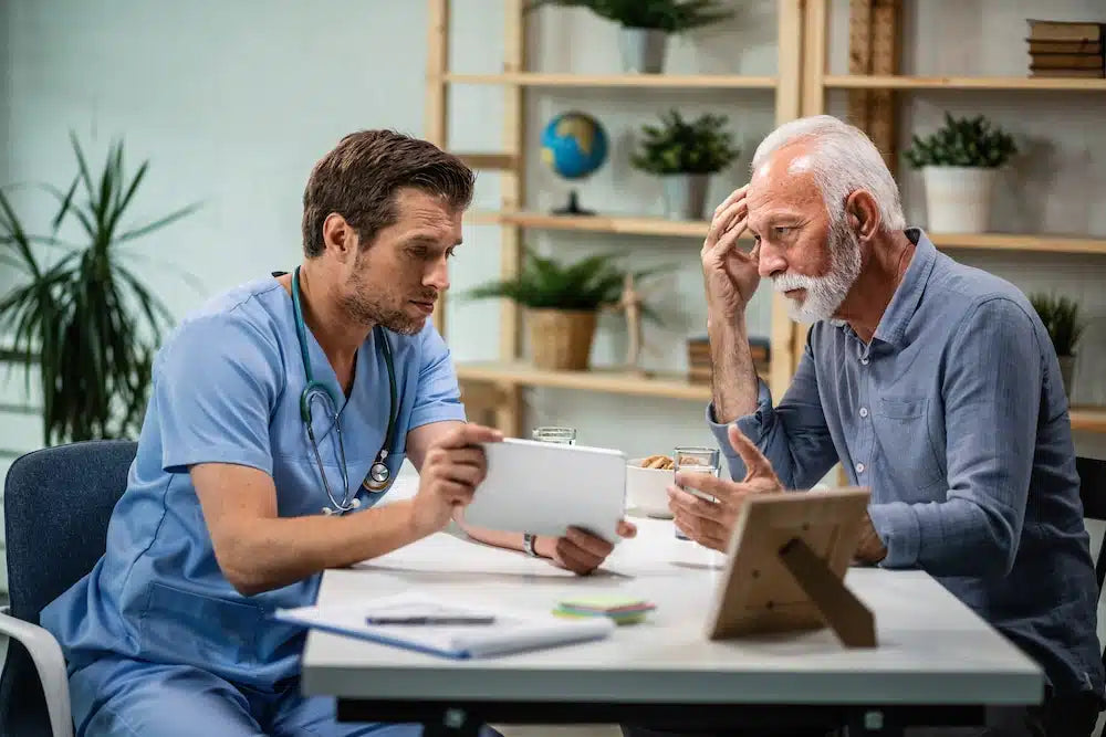 mature-man-feeling-concerned-while-talking-his-doctor-who-is-showing-him-medical-test-results-digital-tablet